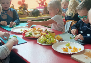 Przedszkolaki kroją owoce do sałatki